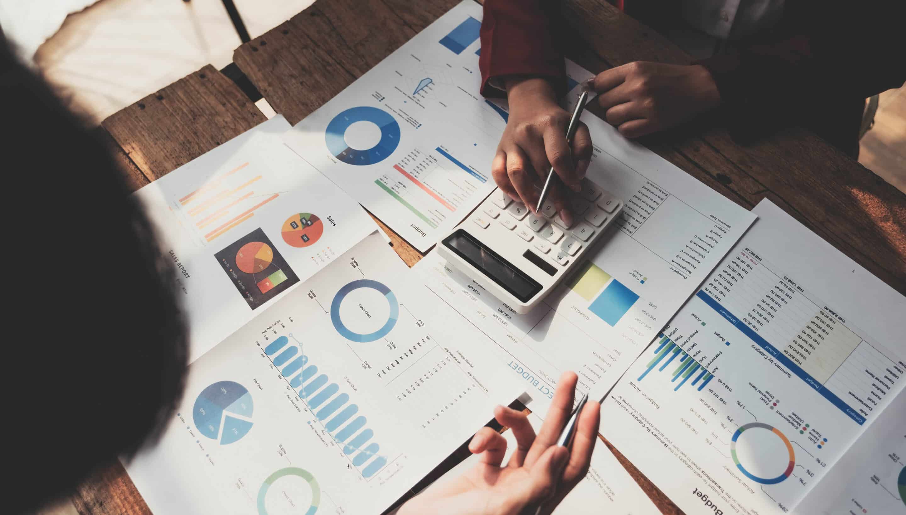 Business People Meeting using laptop computer,calculator,notebook,stock market chart paper for analysis Plans to improve quality next month. Conference Discussion Corporate Concept..